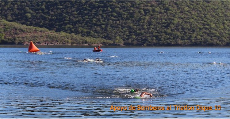 Triatln Dique 10: nadadores cruzando la 2da boya. Al fondo bomberos atentos en una lancha